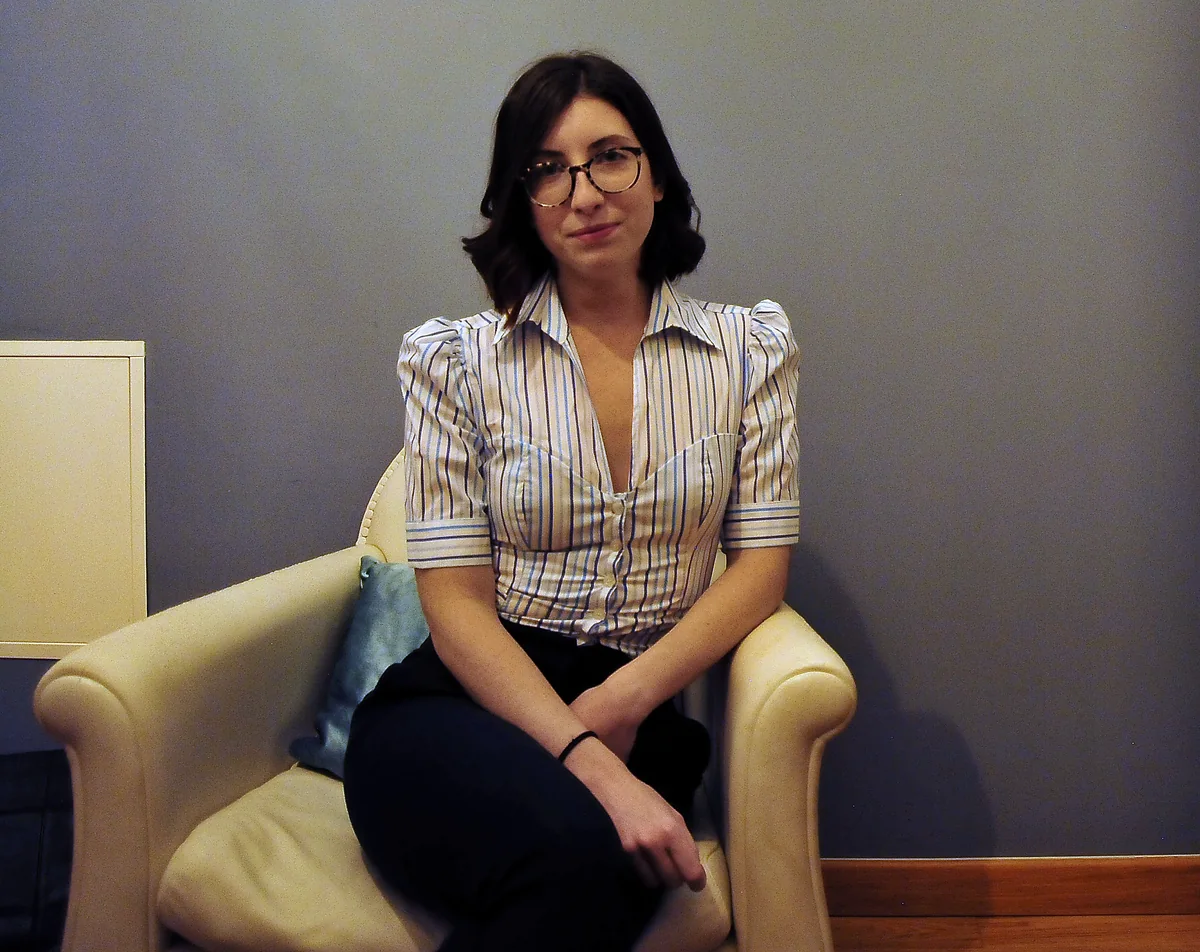 Laura Poddighe seduta in poltrona nello studio di psicoterapia